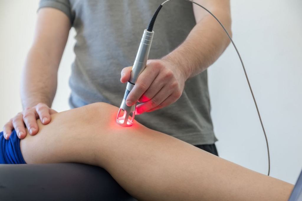 A person receives laser therapy treatment on their knee.